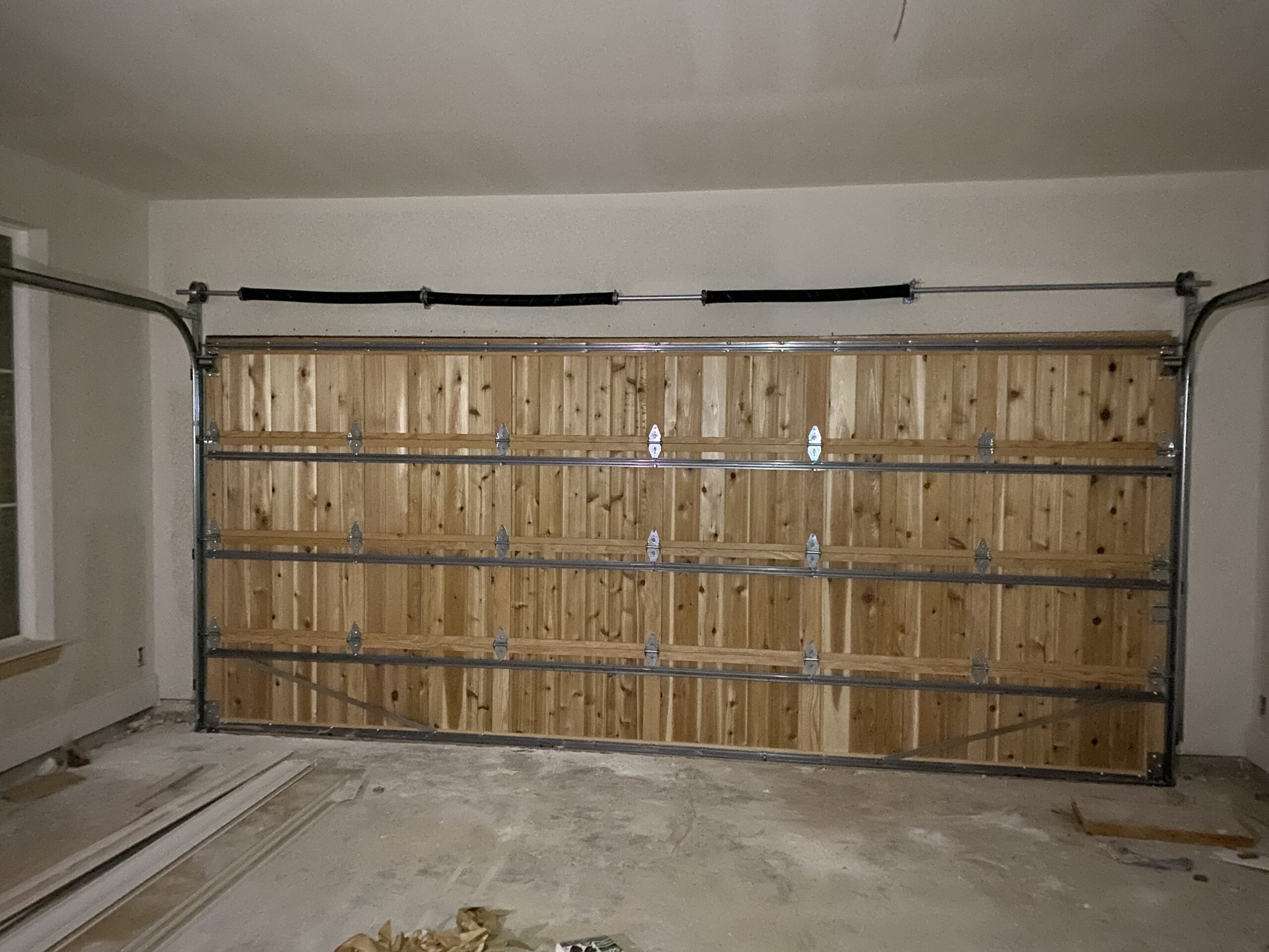 Interior view of a wooden garage door with steel frame support and sectional panels.