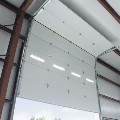 Interior perspective of an industrial building featuring a partially open Amarr 2731 garage door