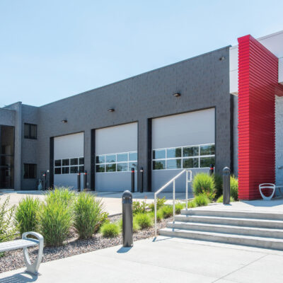 A modern fire station with a row of several Amarr 2742 large garage doors