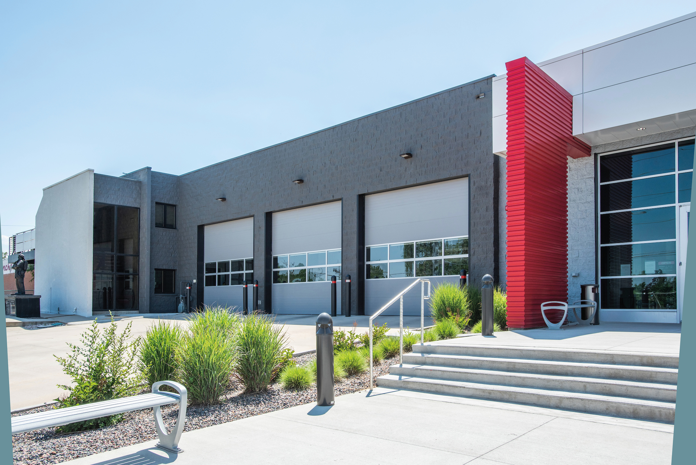 A modern fire station with a row of several Amarr 2742 large garage doors