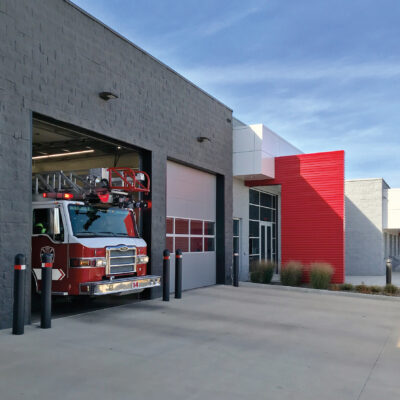 A fire station with multiple open bays with large gray Amarr 2742 overhead doors.