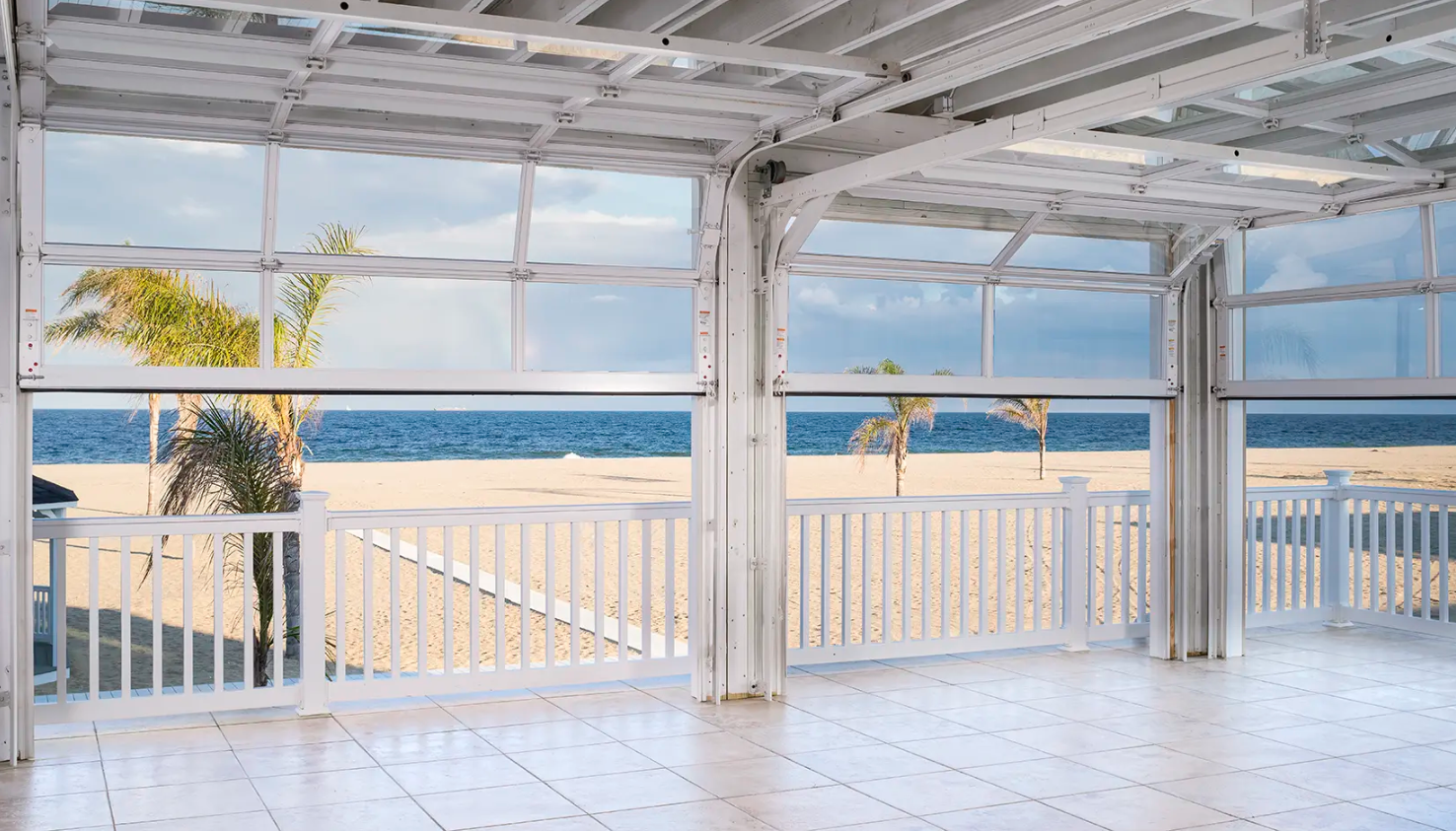 An open-air beachfront event space with multiple large Clopay Architectural Series-Aluminum glass garage doors