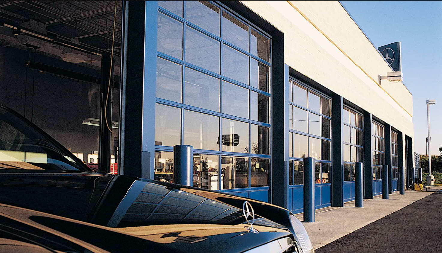 A row of commercial glass garage doors, Clopay Architectural Series-Aluminum, with blue frames