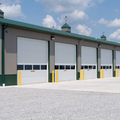 Row of white commercial garage doors with small windows.