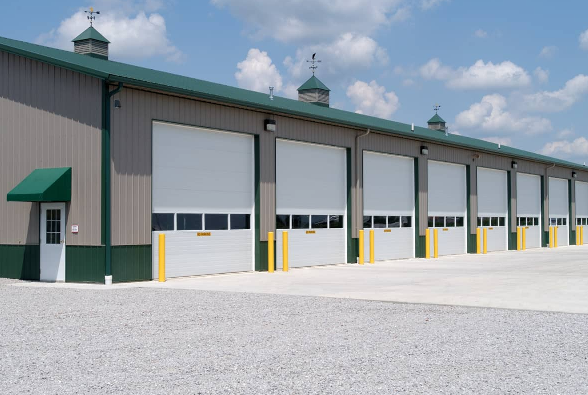 Row of white commercial garage doors with small windows.