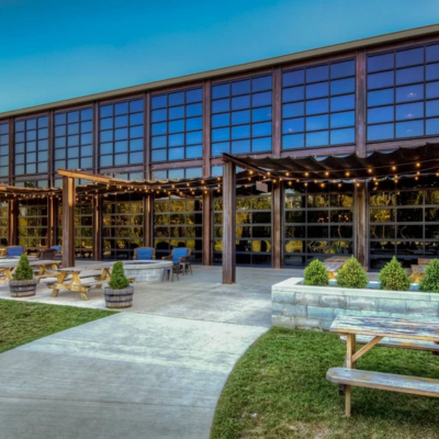 Outdoor patio with picnic tables in front of a large building with many windows