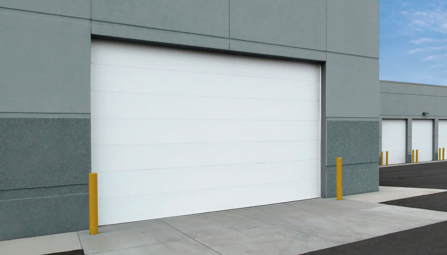 A large white commercial Clopay Energy Series garage door on a modern building