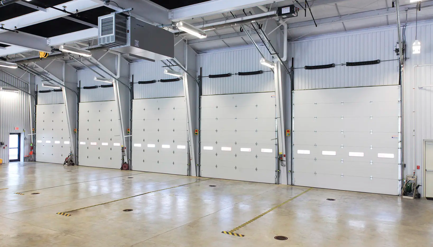 An industrial Clopay Energy Series with Intellicore garage interior with multiple white overhead doors