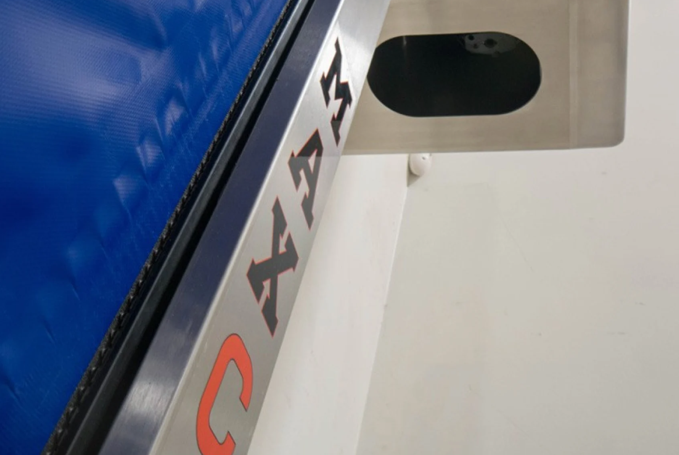 Close-up of a blue industrial door with "MAX CLEAN" label on a metal frame.