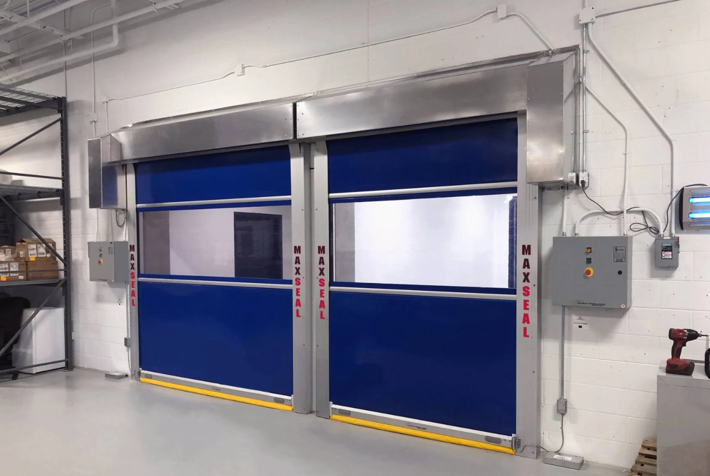 A pair of blue high-speed industrial doors with clear panels, labeled "MAXSEAL".