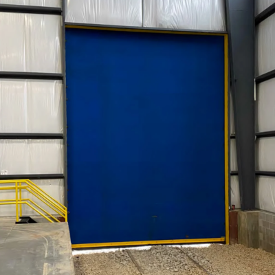 A large blue industrial door with a yellow frame, in a warehouse setting.