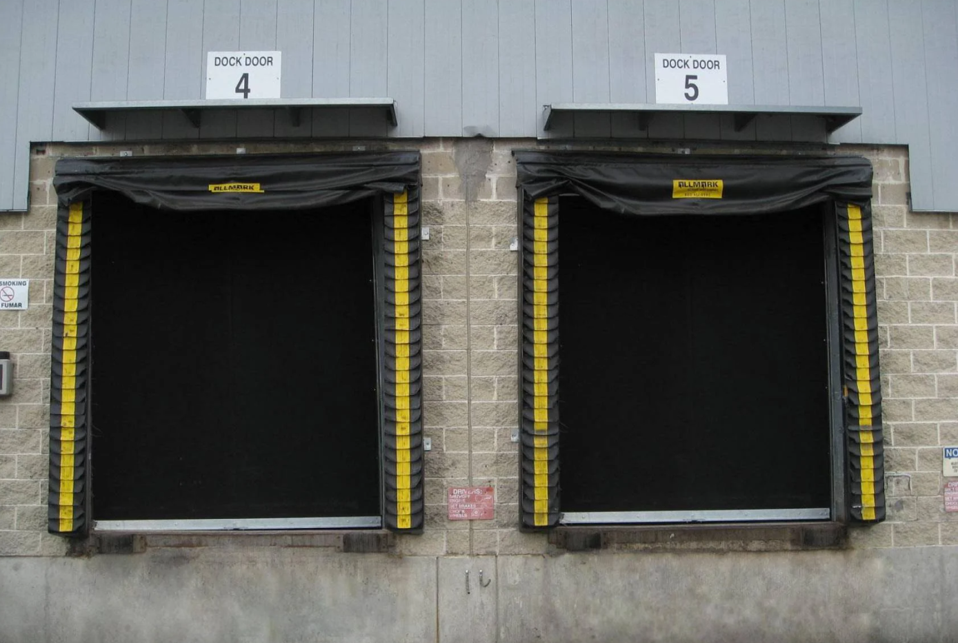 Two loading dock doors labeled 4 and 5 with black curtains and yellow safety stripes.