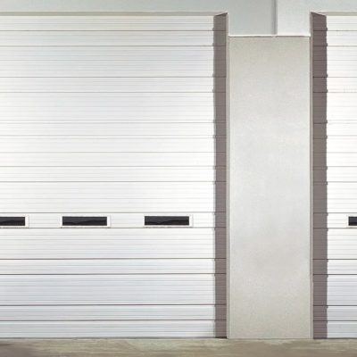 A white Clopay Industrial Series garage door with horizontal grooves and a row of small windows