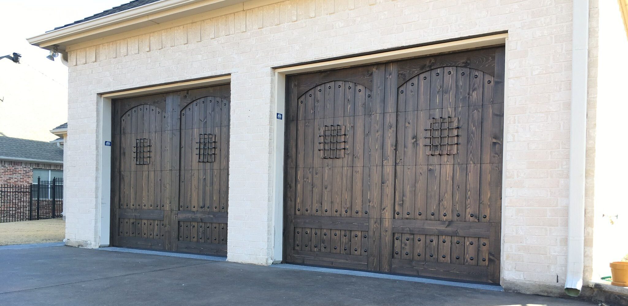 garage door with arched speakeasy and clavos