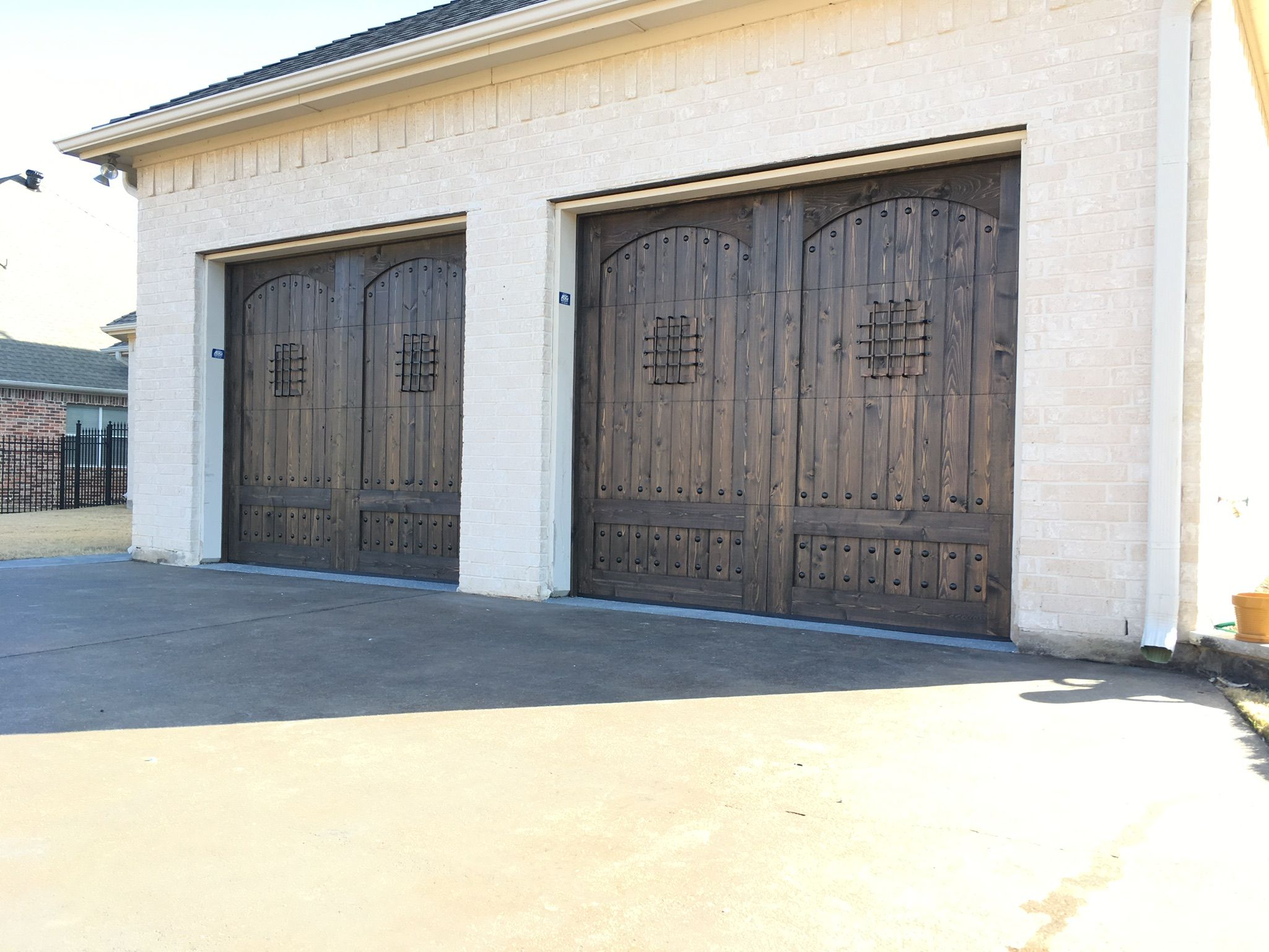 garage door with arched speakeasy and clavos